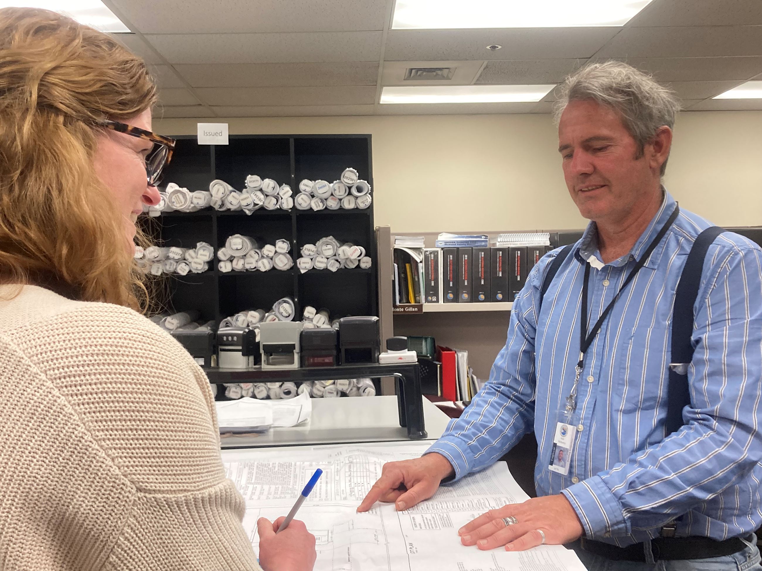 Staff review plans with potential client for Over the Counter Wednesday.