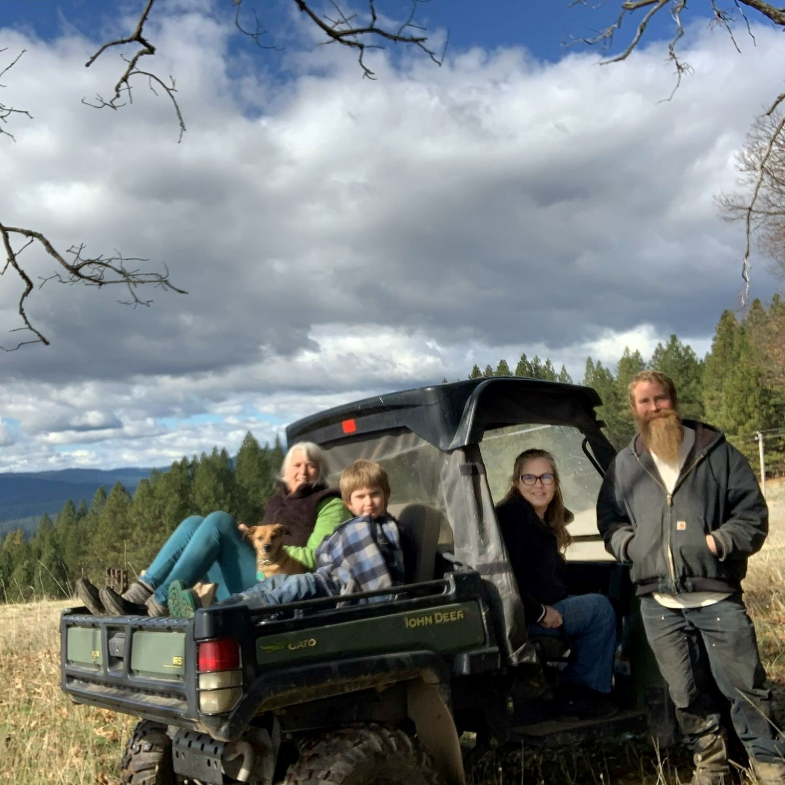 Ana Acton and her family seared in and gathered around an off-road vehicle.