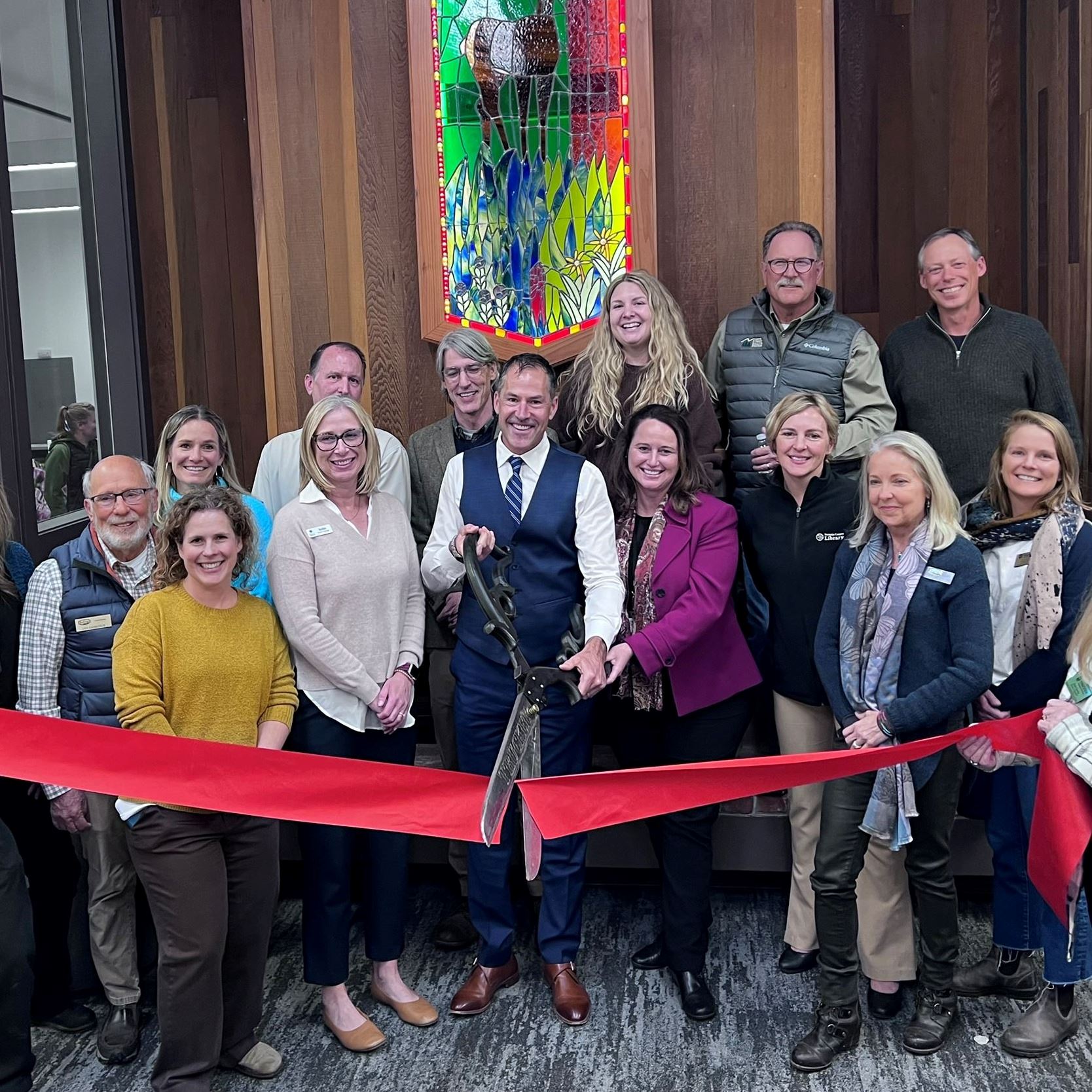Staff cutting red ribbon in front of new library interior