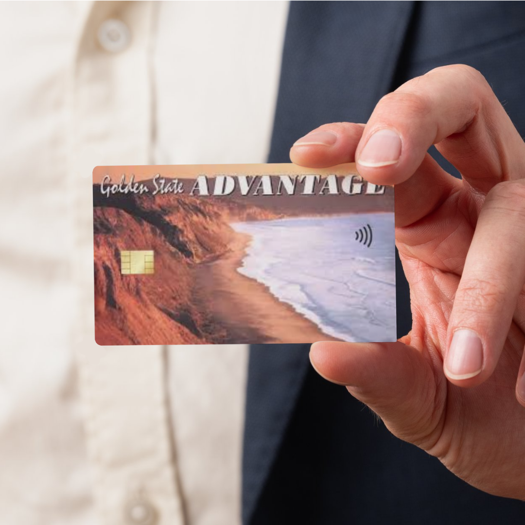 A man wearing a suit holding a EBT card with a chip and a tap icon