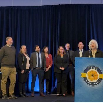 Photo of Public Health Staff with Supervisors Hardy and Swarthout accepting CSAC award on stage. 