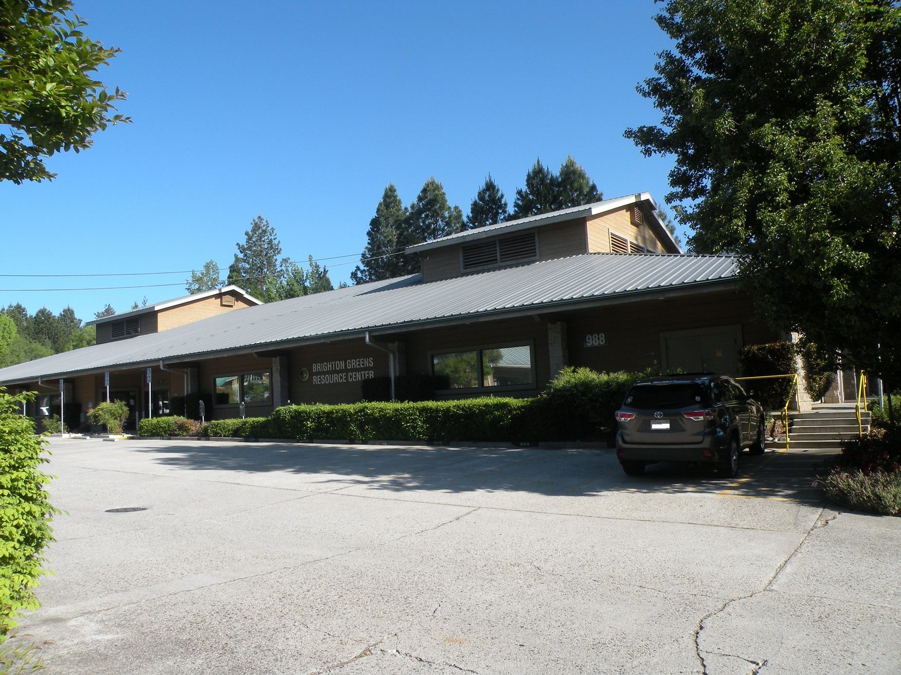 Brighton Greens Building with parking lot and hedges