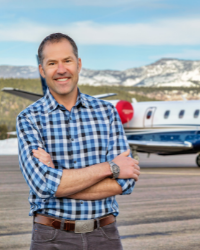Hardy Bullock, smiling, standing in front of an airplane