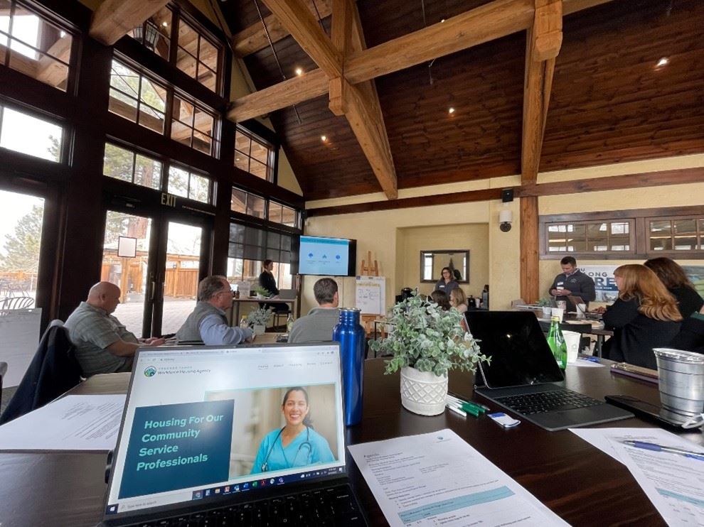 A small group of people gathered in a conference room with laptops and documents