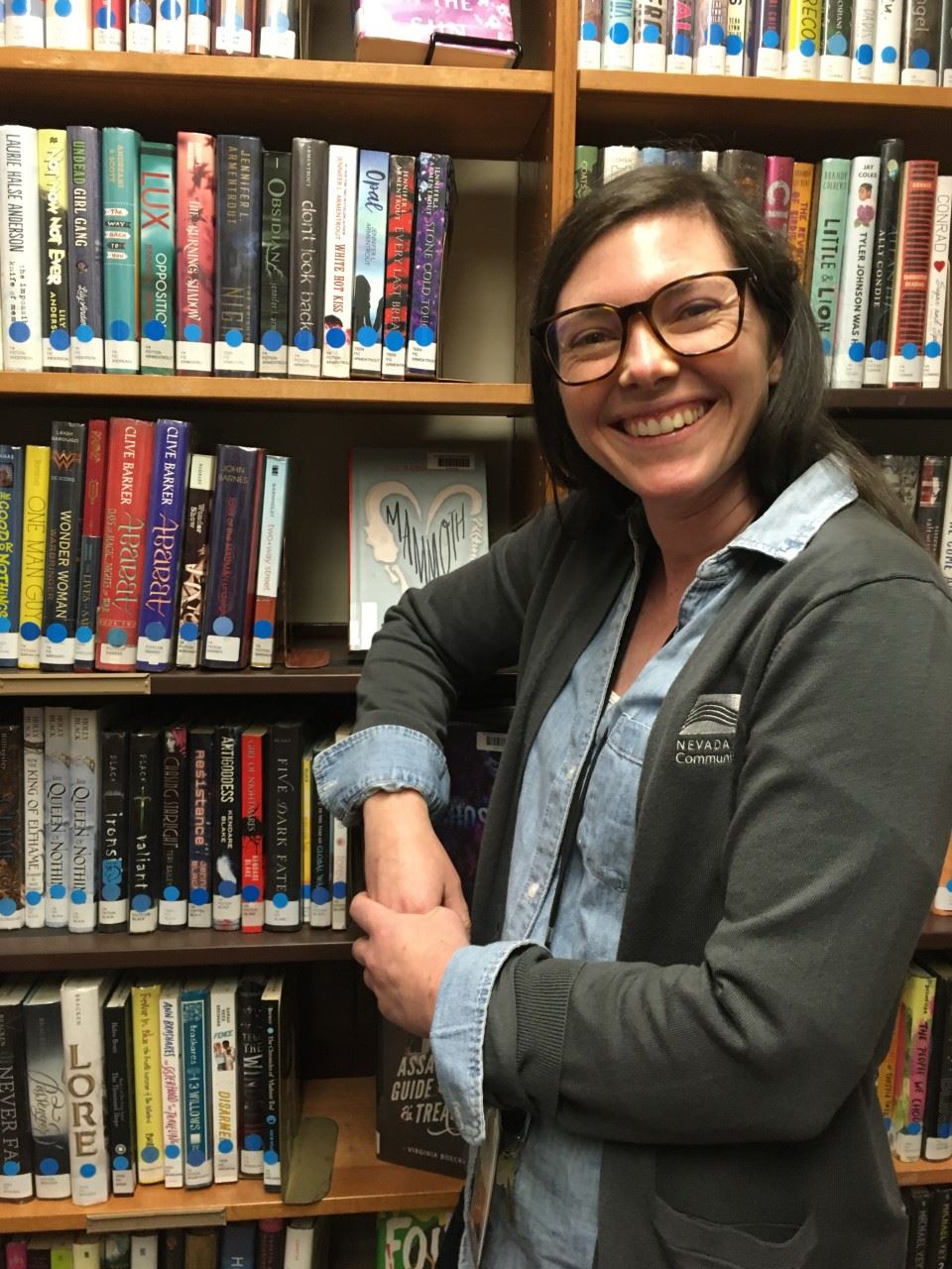 Maggie standing in front of bookshelves 