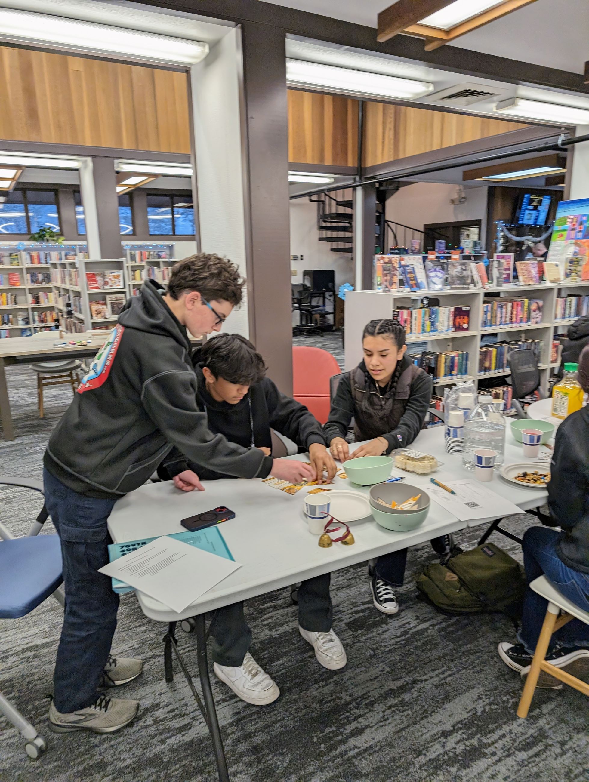 Three teens putting together a puzzle.