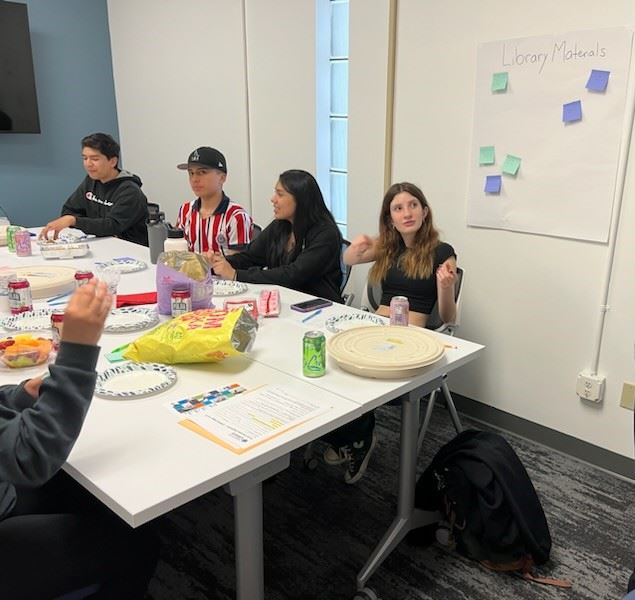 Teens talking at a meeting.
