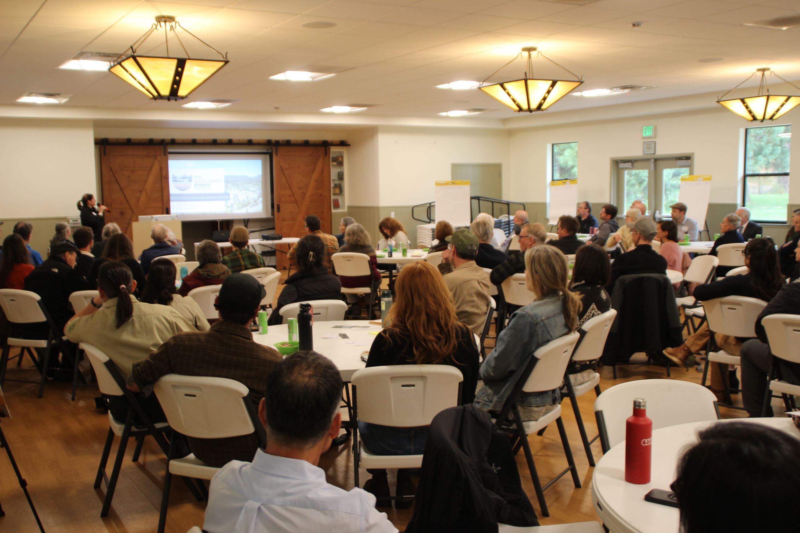 Room full of community members listening to a presentation